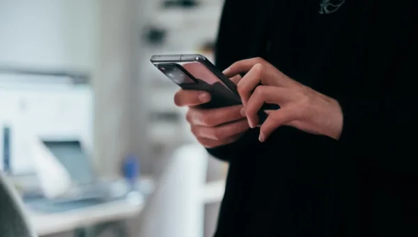 Person thoughtfully looking at phone while crafting a response to can we talk later text message
